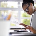 Female African American financial advisor typing on a calculator. Online Life Insurance Quotes: Secret Tips Advisors Need to Know for Your Clients