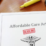 Affordable Care Act (ACA) document on an office desk with a red deadline stamp