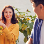 Close up of mature couple watering and pruning plants In garden at home, illustrating the blog topic "Your Passport to Freedom: Navigating Health Insurance as an Early Retiree"